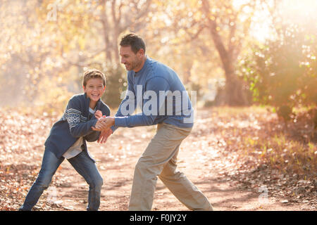 Père et fils ludique sur le chemin dans les bois Banque D'Images