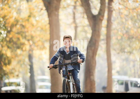 Smiling boy le vélo dans le parc Banque D'Images