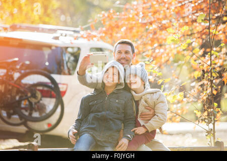 Père et fils en tenant en selfies autumn park Banque D'Images