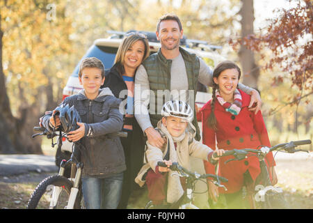 Portrait smiling family avec des bicyclettes à l'extérieur Banque D'Images