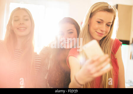 Les adolescentes en tenant avec selfies téléphone appareil photo Banque D'Images