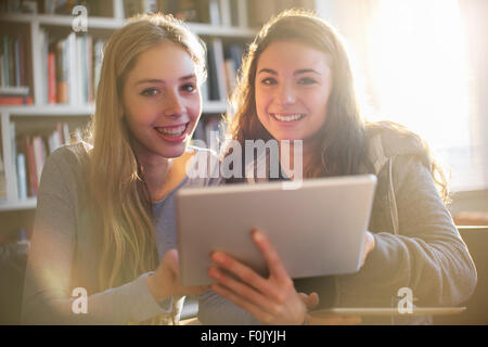 Portrait of smiling teenage girls using digital tablet Banque D'Images