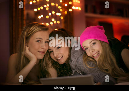 Portrait of smiling teenage girls using digital tablet Banque D'Images