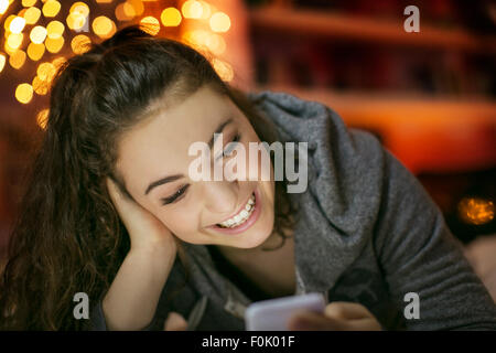 Smiling woman texting with cell phone Banque D'Images