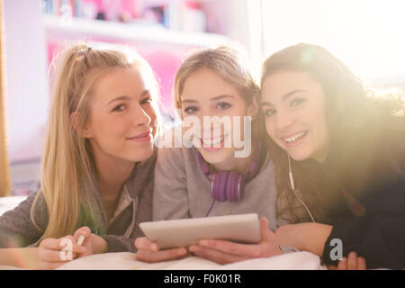 Portrait of smiling teenage girls using digital tablet Banque D'Images