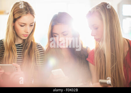 Les jeunes filles à l'aide de téléphones mobiles Banque D'Images