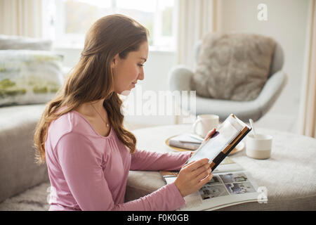 Woman using digital tablet in living room Banque D'Images