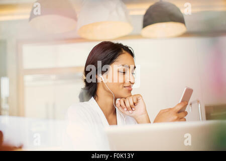 Femme avec casque d'écoute de musique sur lecteur mp3 Banque D'Images