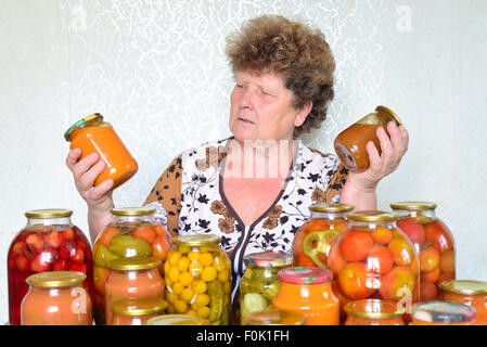 Femme au foyer mature avec des légumes en conserve maison Banque D'Images