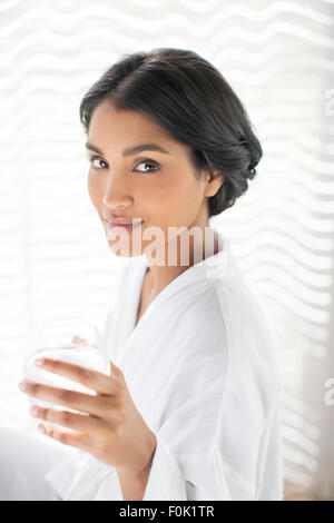 Portrait woman in bathrobe drinking water Banque D'Images