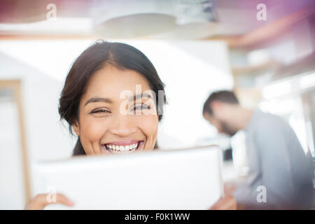 Close up portrait of smiling woman using digital tablet Banque D'Images