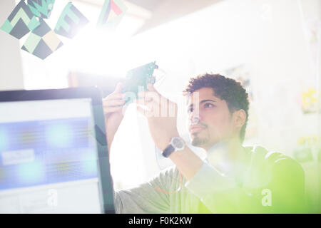 Curieux businessman examining partie in office Banque D'Images