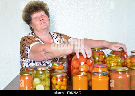 Femme au foyer mature avec des légumes en conserve maison Banque D'Images