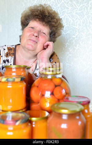 Femme au foyer mature avec des légumes en conserve maison Banque D'Images