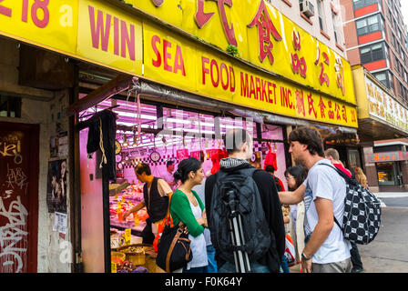 New York City, USA, Chinatown, magasin de poissons, les touristes chinois de la famille à l'extérieur, marché alimentaire de la Mer 'Win', signe, Canal Street Banque D'Images