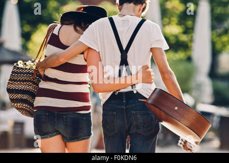 Vue arrière du jeune couple dans l'amour de marcher bras dessus bras dessous Banque D'Images