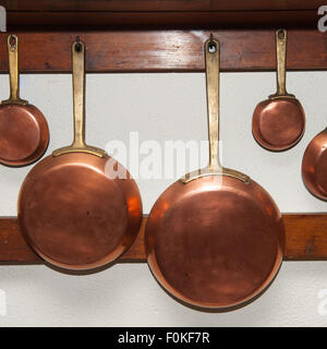 Rangée de vintage en cuir, de taille différente, pendu sur planche en bois dans la cuisine, détail Banque D'Images