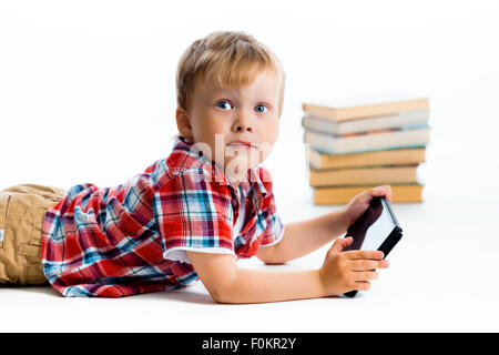 Petit garçon dans une chemise à carreaux avec un ordinateur tablette sur un fond blanc. Banque D'Images