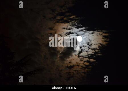 La lune émerge de derrière les nuages menaçants au-dessus de Vancouver, Colombie-Britannique, Canada. Banque D'Images