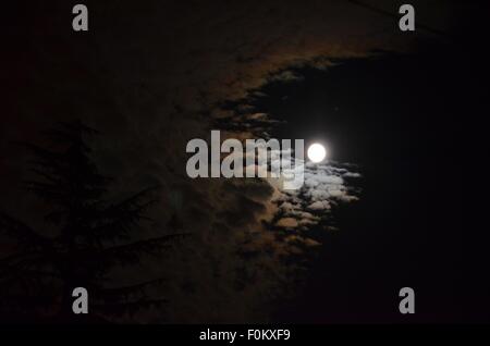 La lune émerge de derrière les nuages menaçants au-dessus de Vancouver, Colombie-Britannique, Canada. Banque D'Images