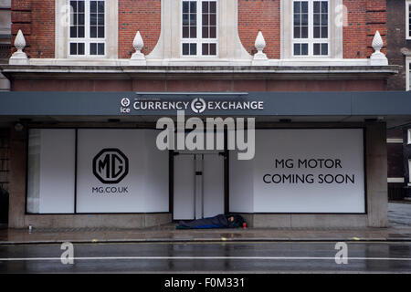 MG Motor prochainement dans Piccadilly, Londres. Un cher London district mais avec un lit sur la chaussée rugueuse à l'extérieur dans la pluie Banque D'Images