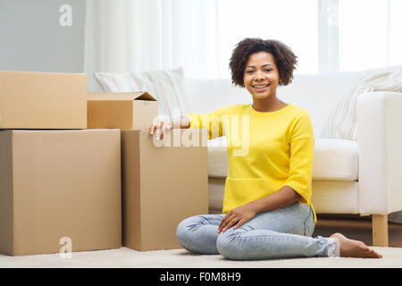 Heureux femme africaine avec des boîtes en carton à la maison Banque D'Images