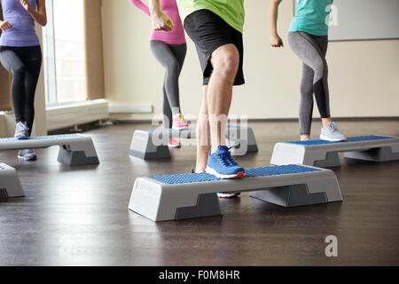 Groupe de personnes la flexion jambes sur les plates-formes étape Banque D'Images