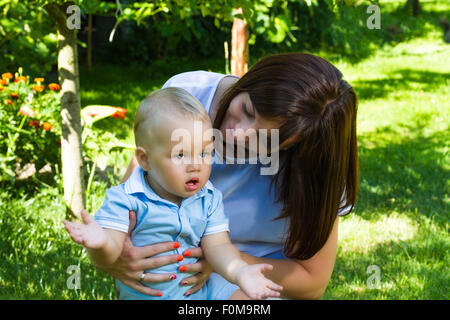 Charmant caucasian baby boy with mother in garden Banque D'Images