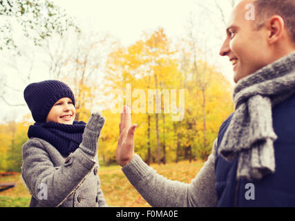 Heureux père et fils en haut cinq in park Banque D'Images