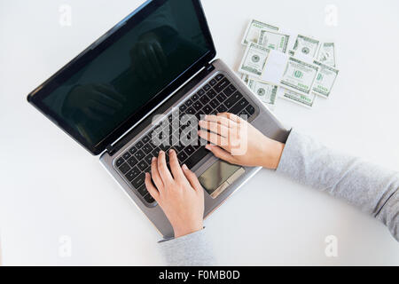 Close up of woman les mains avec de l'argent et l'ordinateur portable Banque D'Images