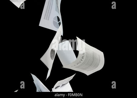 Les papiers d'affaires tomber sur fond noir Banque D'Images