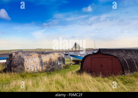 Bateaux renversés utilisés comme abris de pêche - sur l'Île Sainte, Lindisfarne, Northumberland, England, UK Banque D'Images