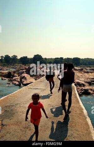 Les baigneurs traversant le pont pied sur la rivière Betwa dans Orchha village, Madhya Pradesh, Inde du Nord. Banque D'Images