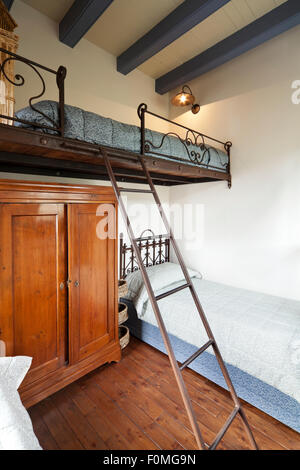 Chambre à l'intérieur, de l'élément fer forgé. Ancienne chambre avec deux lits et personne dans la salle. Armoire en bois Banque D'Images