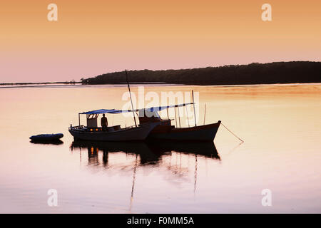 Brian - un bateau silhouetté contre le soleil levant à Bahia, au Brésil Banque D'Images