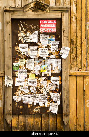 Old style arraché des affiches et déchiré sur une bordure en bois avec panneaux métalliques Banque D'Images