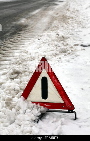Accident. Triangle d'avertissement sur la route d'hiver. Banque D'Images