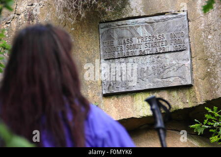 Une femelle walker inspecte la plaque dans la carrière de pont sous gaine qui commémore le sacrifice de masse de Kinder Scout, Derbyshire, Royaume-Uni Banque D'Images