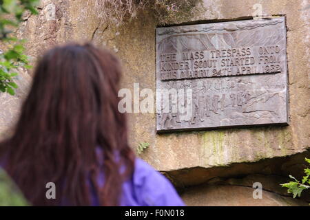 Une femelle walker inspecte la plaque dans la carrière de pont sous gaine qui commémore le sacrifice de masse de Kinder Scout, Derbyshire, Royaume-Uni Banque D'Images