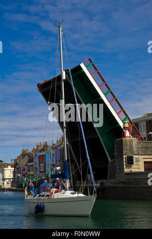 Vue verticale d'un bateau qui passe sous un pont de la ville de Weymouth, Dorset. Banque D'Images