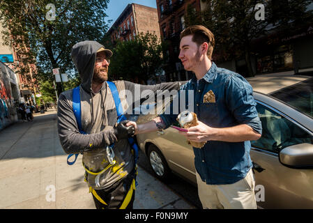 New York, NY - 14 août 2015 - Gustavo Pandolfo (à gauche) l'une des deux artistes de rue brésilien Os Gemeos accueille un ventilateur dans le quartier de l'East Village de Manhattan Banque D'Images