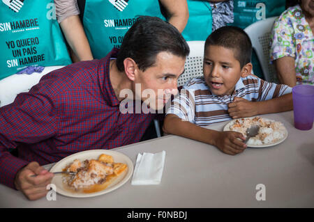 L'État de Michoacan, au Mexique. Août 18, 2015. Le Président mexicain Enrique Pena Nieto (L) parle avec un enfant au cours de sa visite à un souper communautaire de la croisade nationale contre la faim dans la communauté, à Apatzingan Chiquihuitillo State, Mexico, le 18 août, 2015. Credit : NOTIMEX/Xinhua/Alamy Live News Banque D'Images