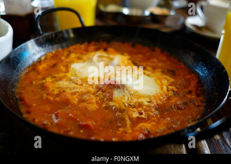 État traditionnels Shakshouka Shakshuka ou qui est un plat d'œufs pochés dans une sauce de tomates, piments, oignons, et servi dans une poêle. Israël Banque D'Images