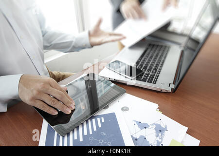 Les documents d'affaires sur la table de bureau avec téléphone intelligent et tablette numérique et graphique Diagramme d'affaires et de l'homme travaillant dans l'arrière-plan Banque D'Images