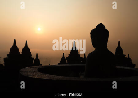 Silhouettes d'une statue de Bouddha au site du patrimoine mondial de l'Unesco le Borobudur temple à l'aube sur l'île de Java, en Indonésie, en Asie. Banque D'Images