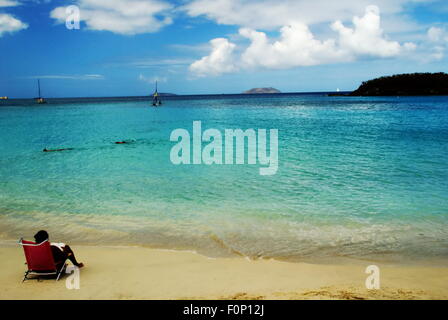 Personne assise sur chaise de plage donnant sur la mer des Caraïbes sur la Cannelle Beach sur l'île de St John, US Virgin Islands. Banque D'Images