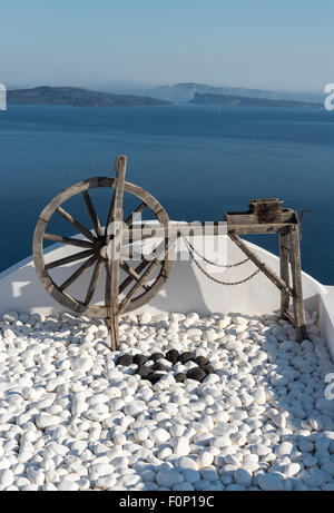 Vieille roue en bois blanc sur le toit-terrasse de chambre à Oia, Santorin, Grèce Banque D'Images