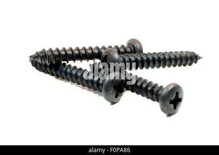 Plusieurs vis noires sur un fond blanc Banque D'Images