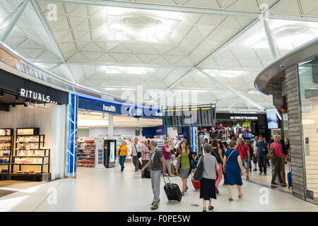 Les passagers, les gens du voyage avec une assurance et des boutiques, change de terminal des départs à l'aéroport de Stansted, Royaume-Uni,Londres Banque D'Images