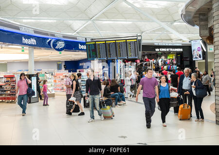 Boots,magasin,store,passagers, les voyageurs avec une assurance et des boutiques, change de terminal des départs à l'aéroport de Stansted, Royaume-Uni,Londres Banque D'Images